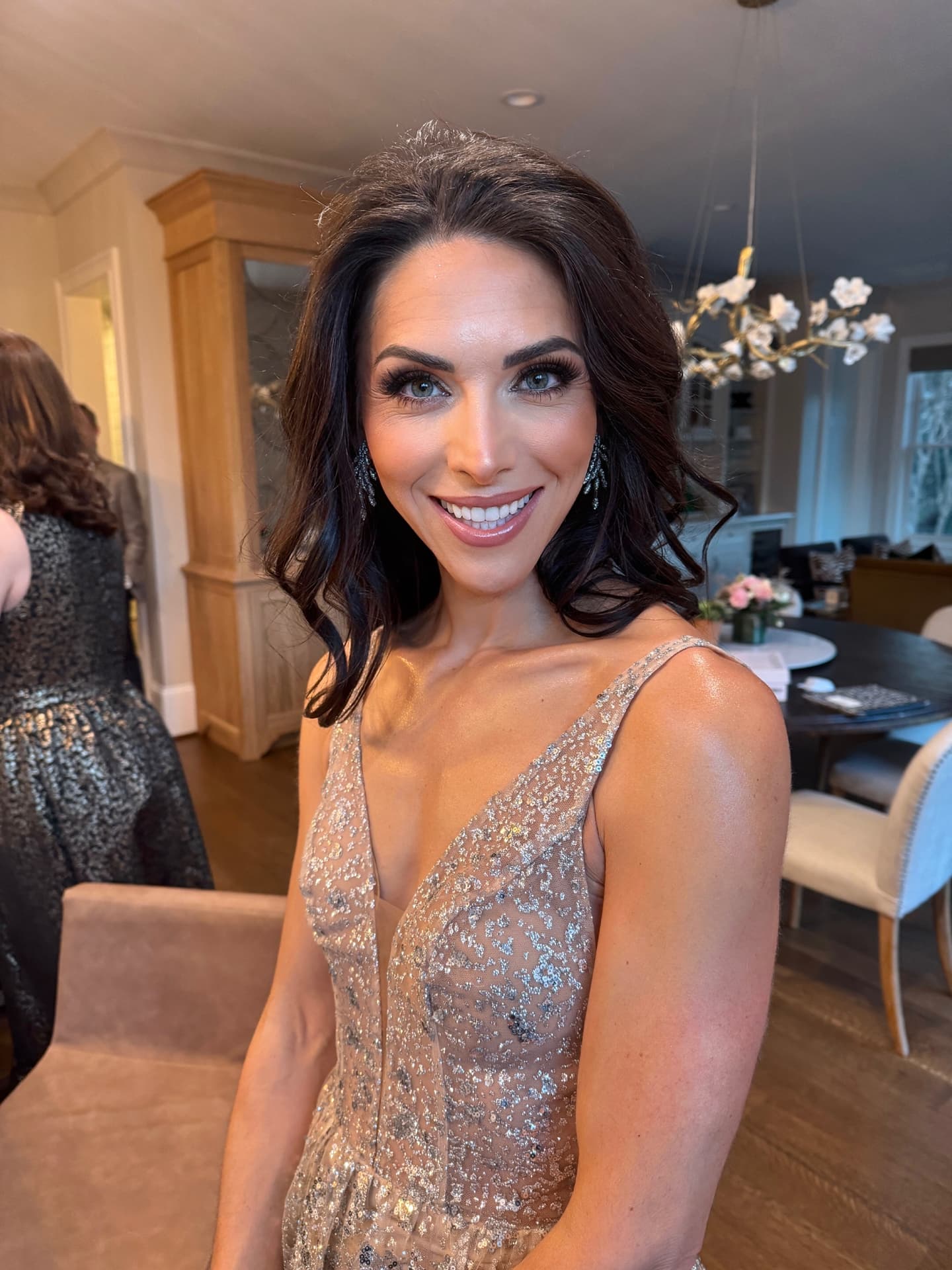 Guest with bronzed glam makeup and glossy lip in a sequin gown