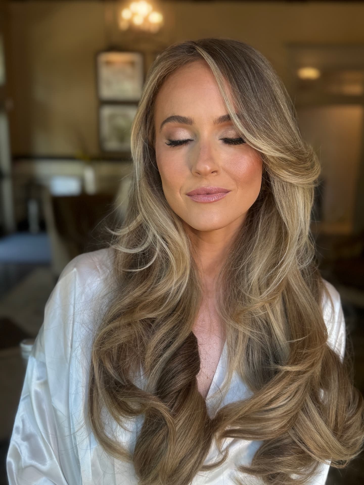 Bride in a silk robe with soft radiant makeup